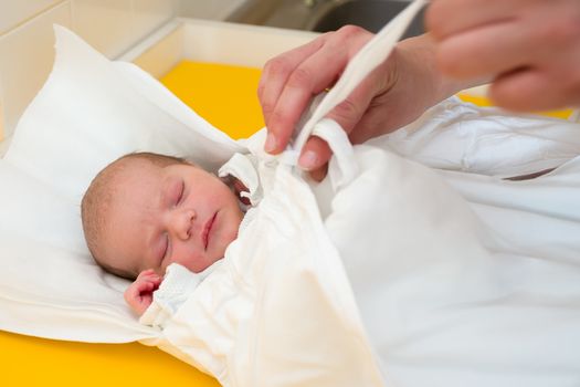 sleeping newborn baby in the hospital - the first hours of the new life