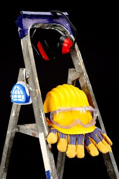 Safety gear kit on step ladder over black 