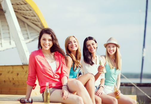 summer holidays and vacation - girls with drinks on the beach