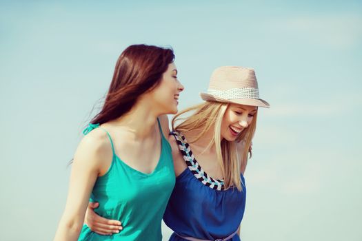 summer holidays and vacation - girls walking on the beach