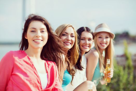 summer holidays and vacation - girls with drinks on the beach