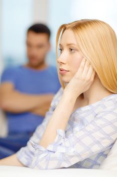 love, family and happiness concept - upset young woman with man on the back at home