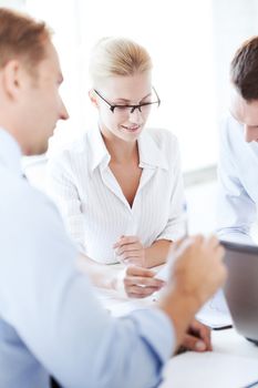 business concept - smiling businesswoman with team on meeting in office