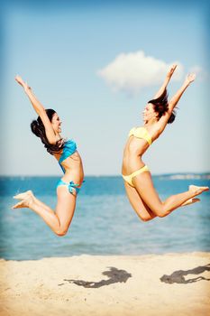 summer holidays and vacation - girls jumping on the beach