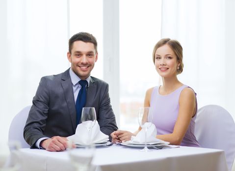 restaurant, couple and holiday concept - smiling couple at restaurant