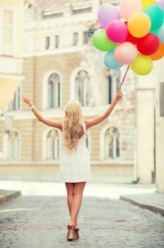 summer holidays, celebration and lifestyle concept - beautiful woman with colorful balloons in the city