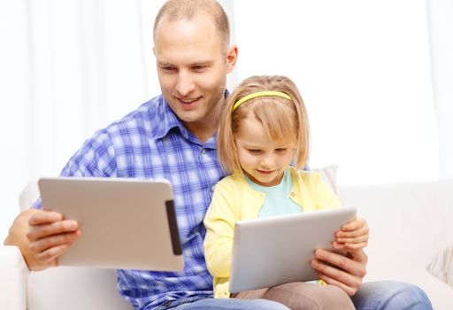 family, children, parenthood, technology and internet concept - happy father and daughter with tablet pc computer at home