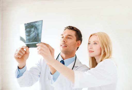 medicine and healthcare concept - smiling male doctor or dentist with nurse looking at x-ray in hospital