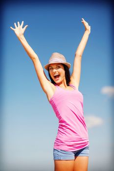 summer holidays and vacation - girl with hands up on the beach