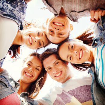 summer holidays and teenage concept - group of teenagers looking down