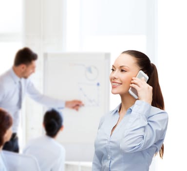 business, technology and education concept - friendly young smiling businesswoman with smartphone in office