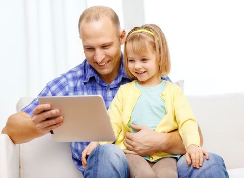 family, children, parenthood, technology and internet concept - happy father and daughter with tablet pc computer at home