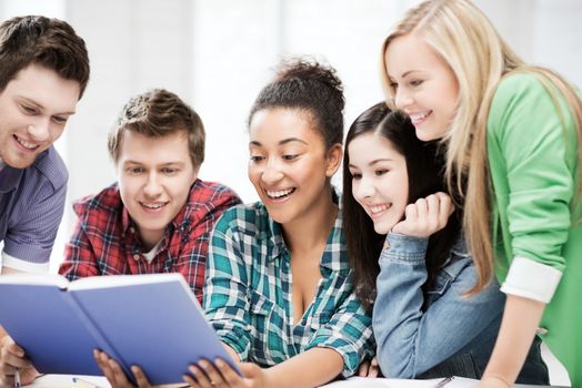 education concept - group of students reading book at school