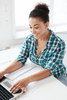 education concept - smiling international student girl with laptop at school