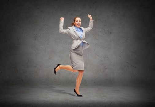 business and education concept - young happy woman jumping with hands up