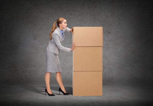 business, post and transportation concept - busy businesswoman pushing tower of cardboards