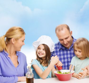 food, family, children, hapiness and people concept - happy family with two kids making dinner at home