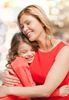 family, child and happiness concept - hugging mother and daughter