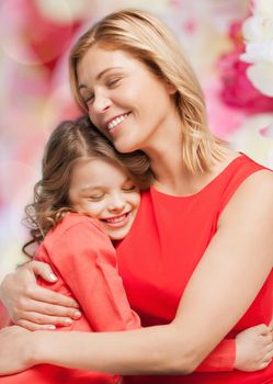 family, child and happiness concept - hugging mother and daughter