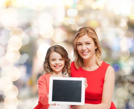 family, child and technology concept - smiling mother and daughter with tablet pc computers blank black screen