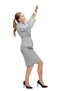 business and education concept - smiling businesswoman pulling imaginary rope