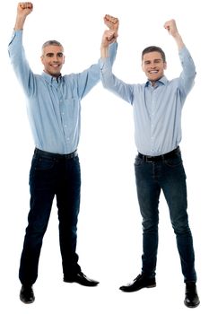 Successful handsome people celebrating with arms up