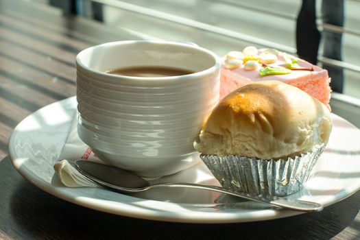 Hot coffee in white cup with sandwich ham&cheese and sweetmeat