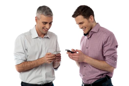 Smiling young men sending messages with mobile phone 