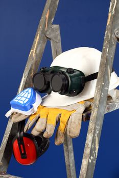 Safety gear kit on step ladder over blue