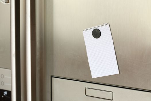 Blank paper and magnet on refrigerator door. 