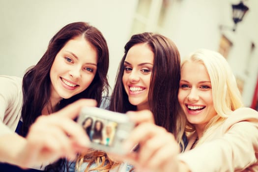 holidays and tourism concept - beautiful girls taking picture in the city