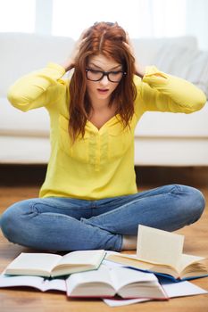 education and home concept - smiling student girl in eyeglasses reading books at home