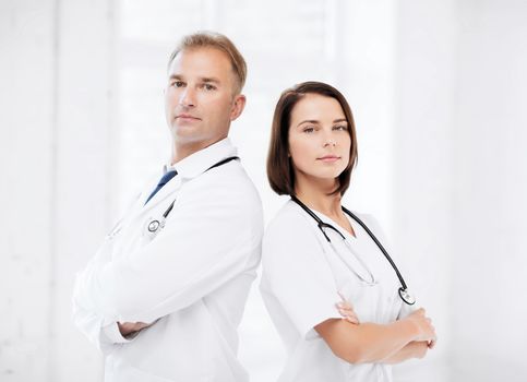 healthcare and medical concept - two doctors with stethoscopes