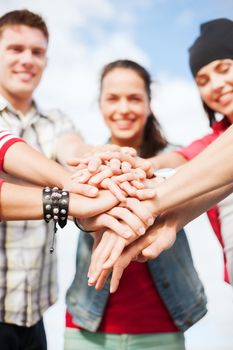 success and gesture concept - close up of teenagers hands on top of each other outdoors