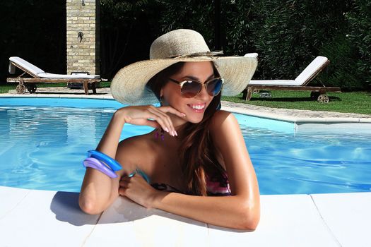 portrait the cute brunette in swimming pool with straw hat sunglasses