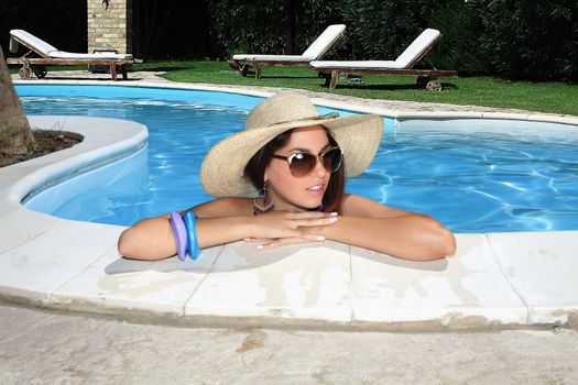 portrait the cute brunette in swimming pool with straw hat sunglasses