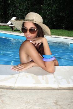 portrait the cute brunette in swimming pool with straw hat sunglasses