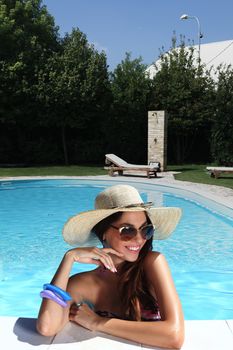 portrait the cute brunette in swimming pool with straw hat sunglasses