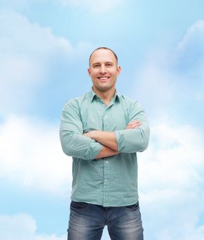 happiness and people concept - smiling man with crossed arms