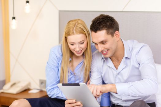 business, hotel, trave and technology concept - smiling couple with tablet pc computer in hotel room