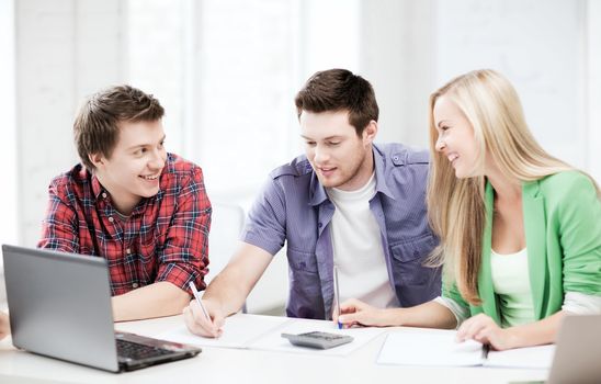 education concept - smiling students chatting in lecture at school