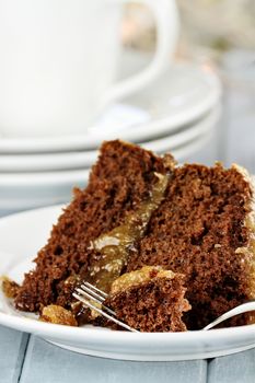 A piece of German chocolate cake on a plate. Shallow depth of field with selective focus on bite on the fork.