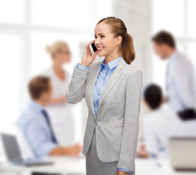 business, technology and education concept - friendly young smiling businesswoman with smartphone