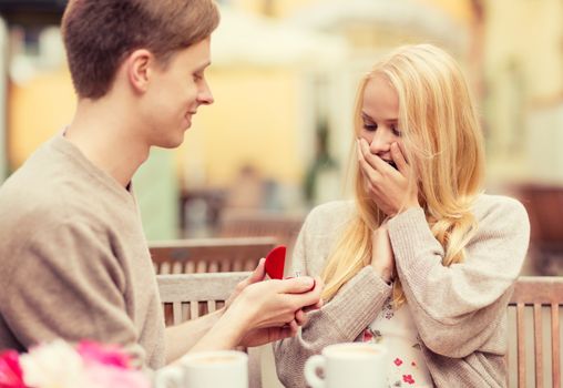 summer holidays, love, travel, tourism, relationship and dating concept - romantic man proposing to beautiful woman