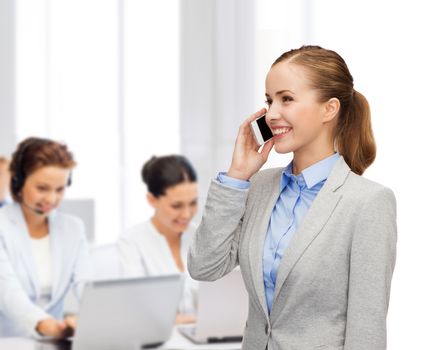 business, technology and education concept - friendly young smiling businesswoman with smartphone