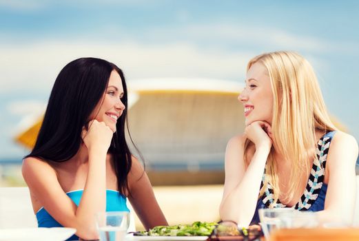 summer holidays and vacation - girls in cafe on the beach