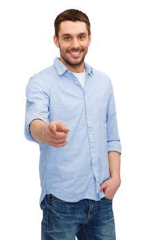 happiness and people concept - smiling man pointing finger at you