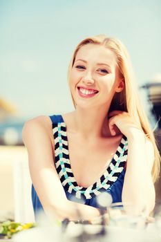 summer holidays and vacation - girl in cafe on the beach