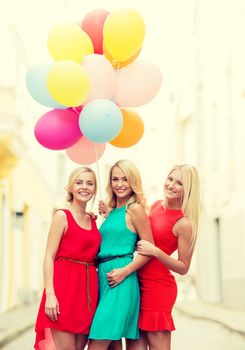 holidays and tourism, friends, hen party, blonde girls concept - three beautiful women with colorful balloons in the city