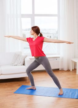 fitness, home and diet concept - smiling teenage girl streching at home